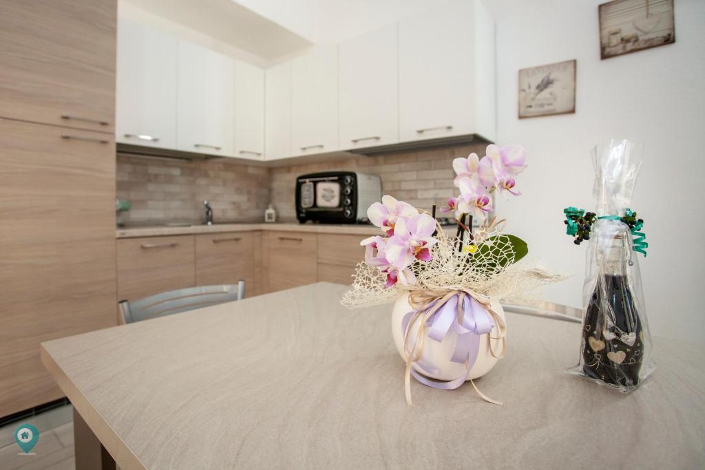 a vase of flowers on a table in a kitchen at Villino Grosseto in San Teodoro