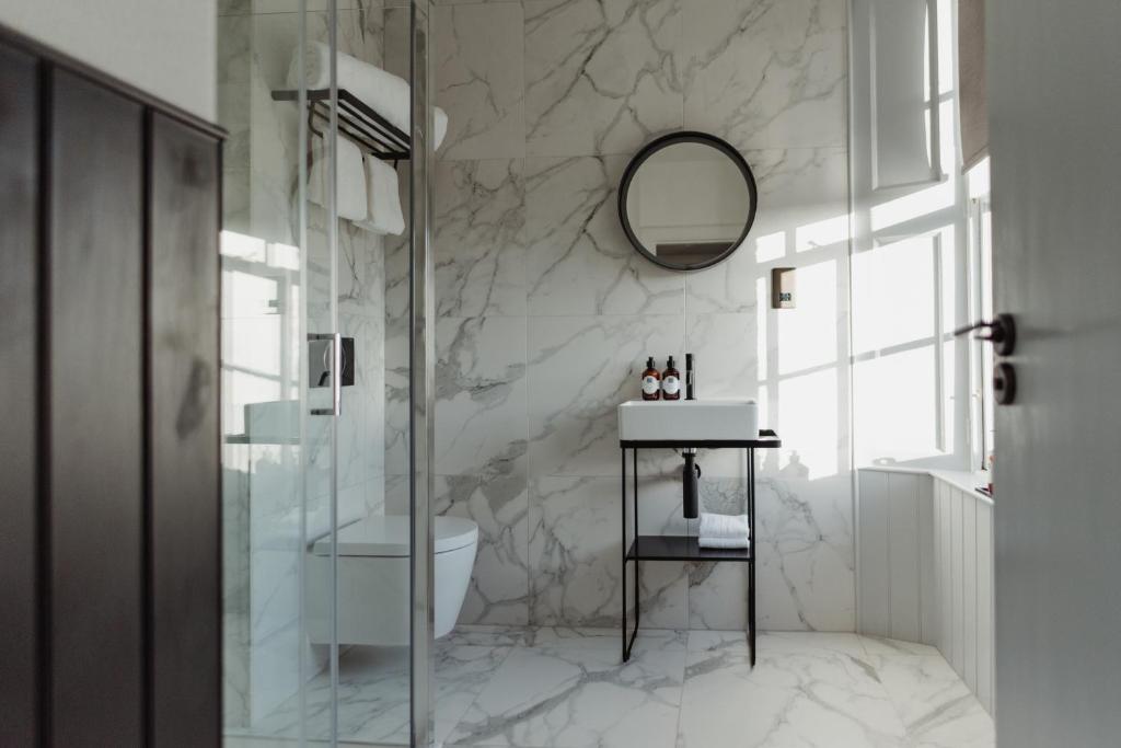 a bathroom with a shower and a sink and a mirror at The Bonnie Badger in Gullane