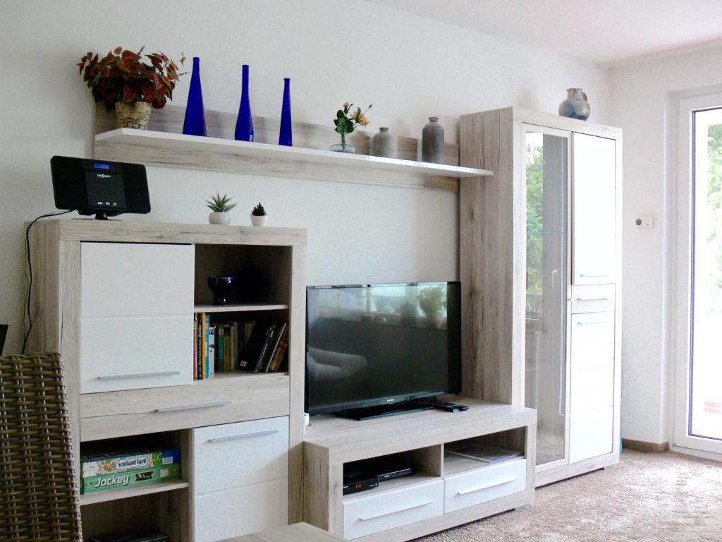 ein Wohnzimmer mit einem TV in einem weißen Unterhaltungszentrum in der Unterkunft Ferienwohnung Hudewusch in Bad Harzburg