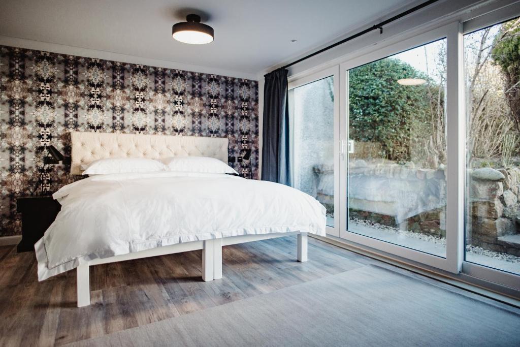 a bedroom with a white bed and a window at The Bonnie Badger in Gullane