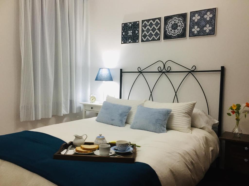 una camera da letto con un letto e un vassoio di cibo sopra di CASA EL CALLEJON DE BENAMAHOMA a Benamahoma