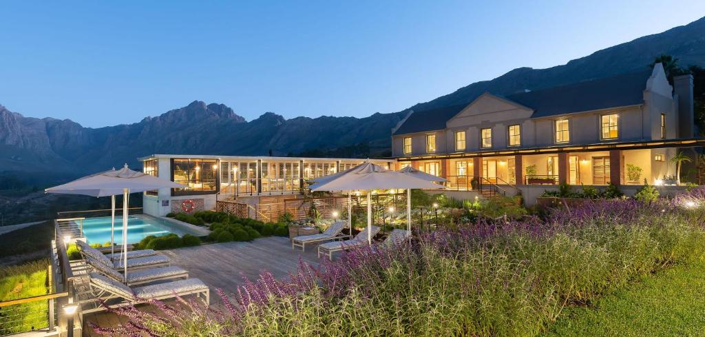 a large building with a pool and umbrellas at De Zeven in Stellenbosch