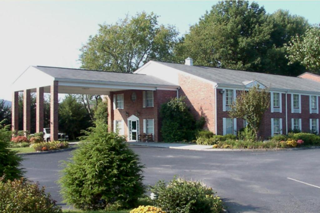 un gran edificio de ladrillo rojo con aparcamiento en Americourt Hotel and Suites - Elizabethton en Elizabethton