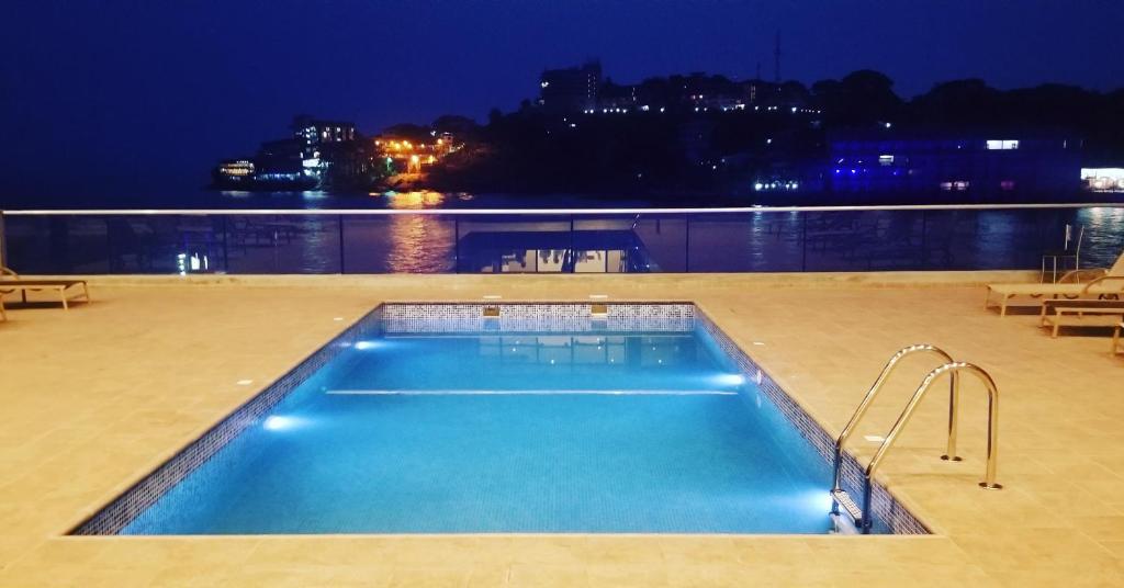 a swimming pool at night with a view of the water at Mamba Point Hotel in Freetown