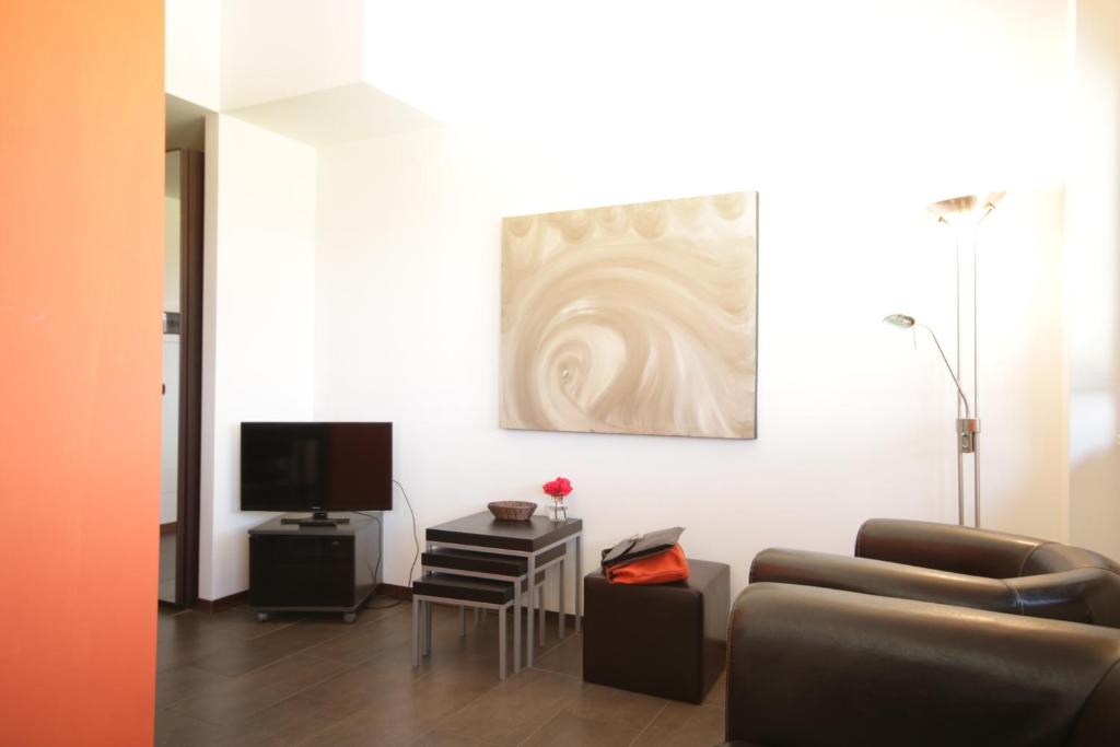 salon z kanapą i telewizorem w obiekcie Della Piana Residence w mieście Aprilia