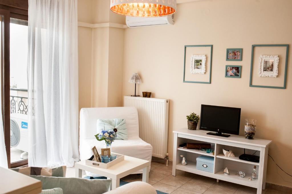 salon z białym krzesłem i telewizorem w obiekcie Sea view flat w mieście Perea