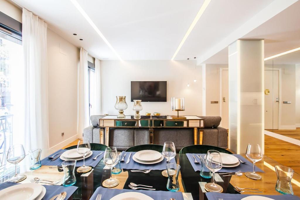 a dining room with a table and chairs and a tv at Luxury Apartment Salamanca District in Madrid