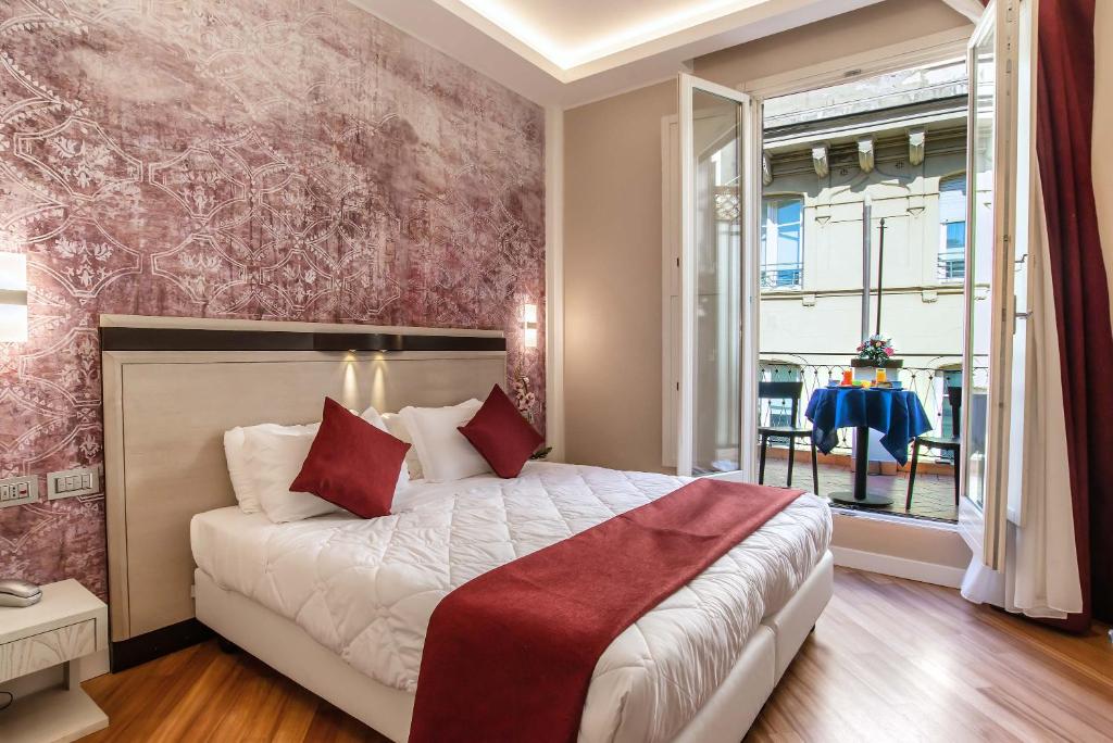a bedroom with a large bed with red pillows at Hotel Memphis in Rome