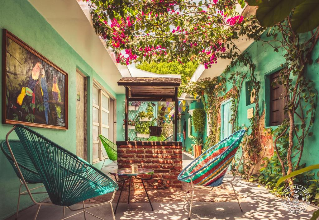 um quarto com cadeiras, uma mesa e flores em Casa Del Pozo Boutique Hostel em Cartagena das Índias