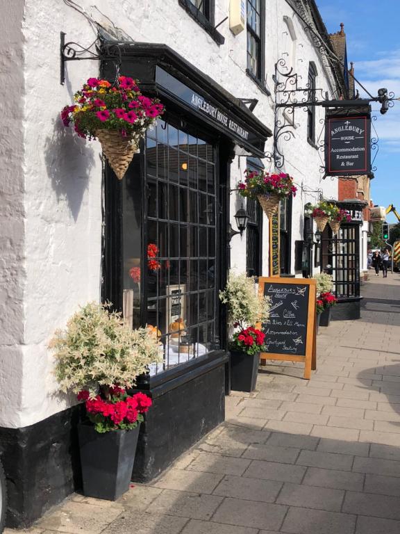 a store with flowers in pots on the side of a building at Anglebury House in Wareham