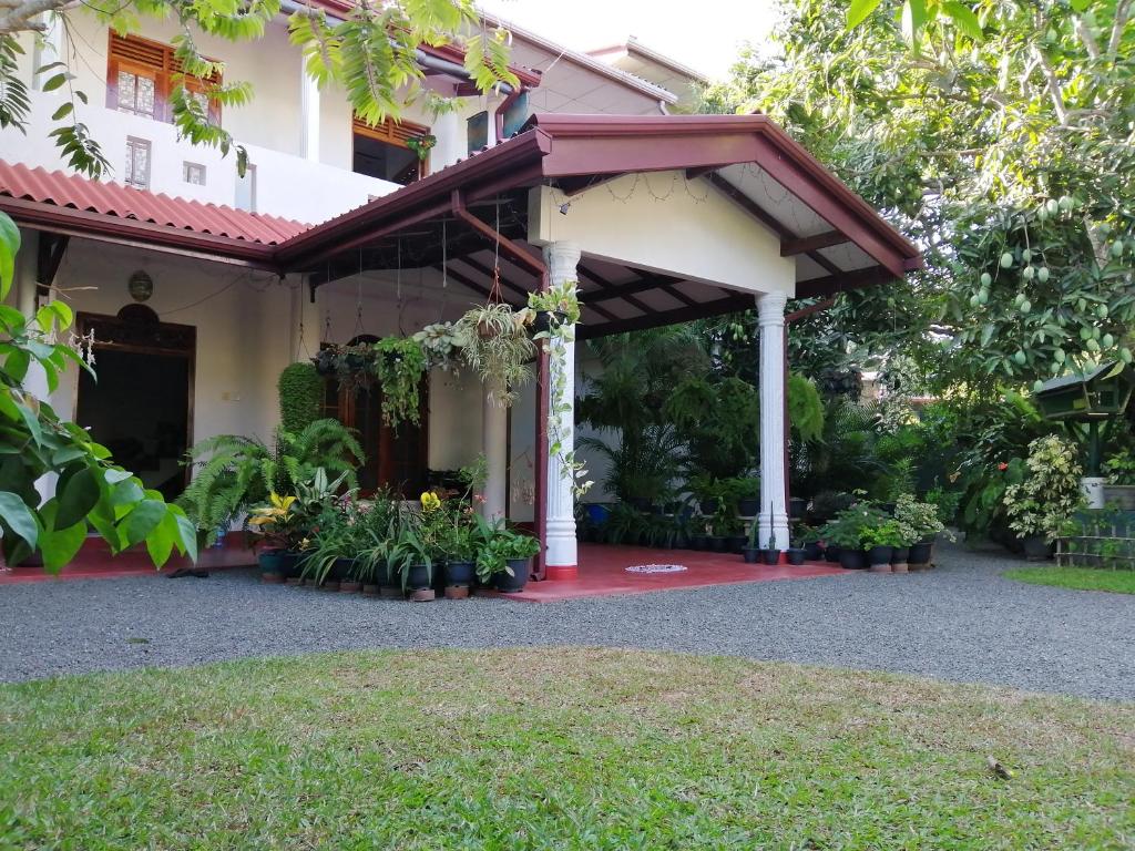 a porch of a house with flowers and plants at Kanthi Holiday Rest Homestay in Mirissa