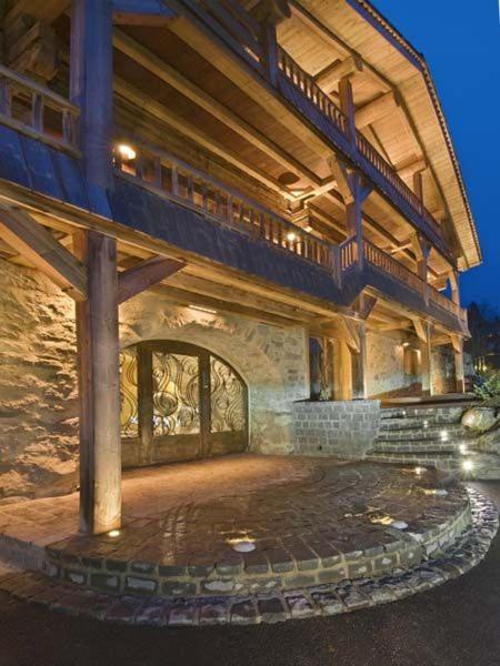 un grand bâtiment avec une terrasse et des escaliers. dans l'établissement Chalet La Patna, à La Clusaz