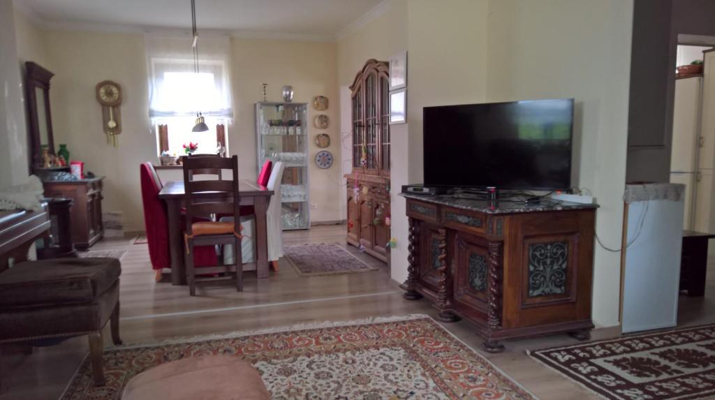 sala de estar con TV de pantalla plana y mesa en Ferienhaus Inselweg en Faak am See