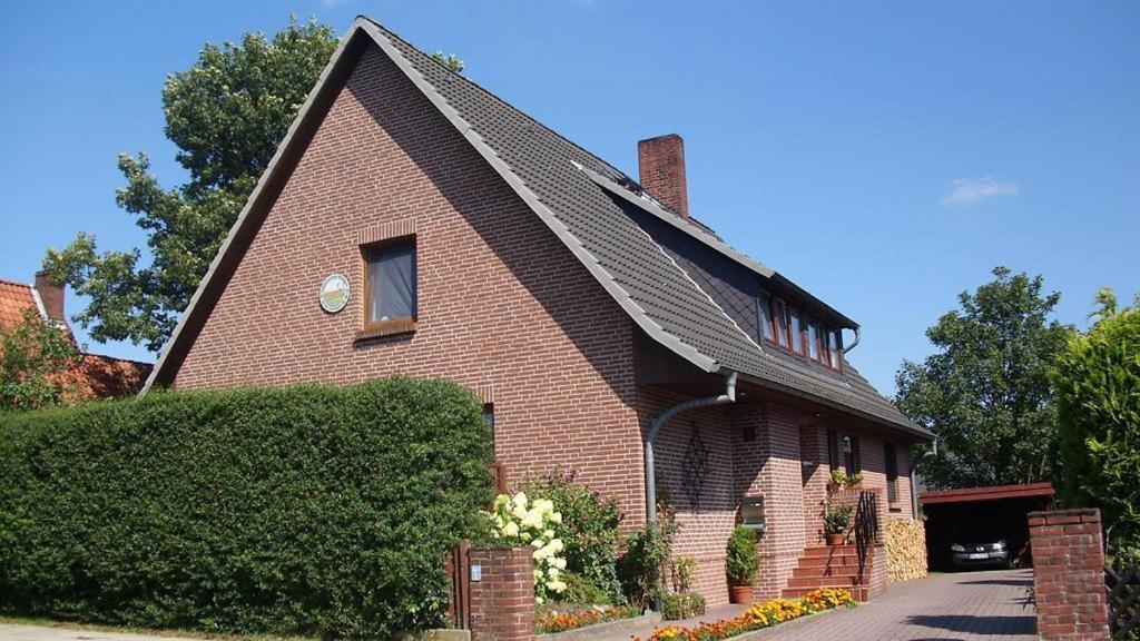 a red brick house with a pointed roof at Ferienwohnung Sommerfeld in Bispingen