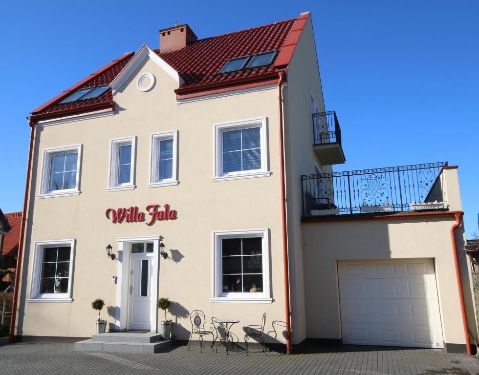 a white house with a red roof at Willa Fala in Hel