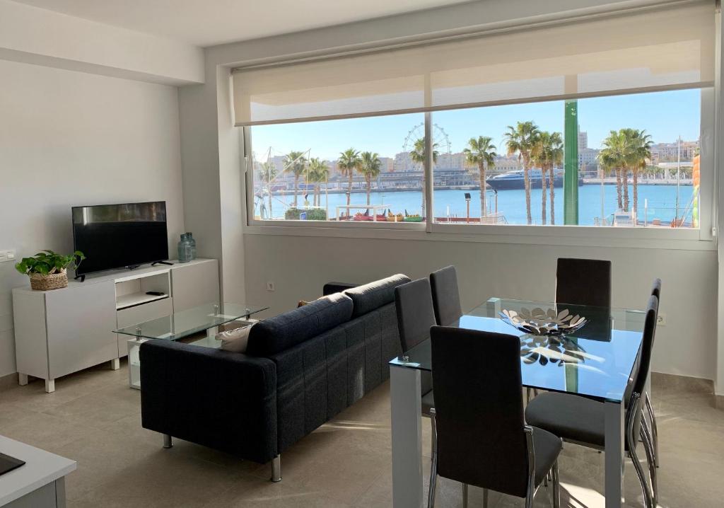 uma sala de estar com um sofá e uma mesa em Diamond Apartments Puerto De Malaga em Málaga