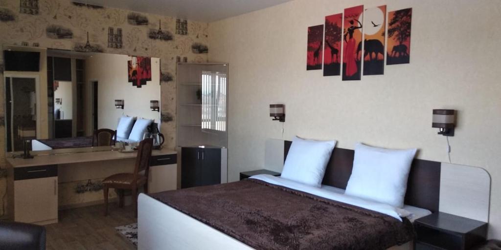a bedroom with a bed and a desk and a mirror at Savanna in Ryazan