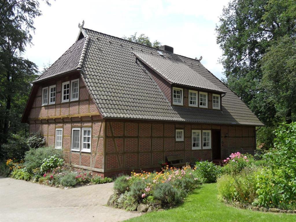una casa con techo de gambrel y jardín en Ferienwohnungen Zum Hülsenbusch en Bispingen