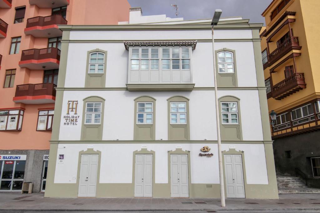 a white and green building with six doors at Hotel Emblemático Holiday Time in Santa Cruz de la Palma