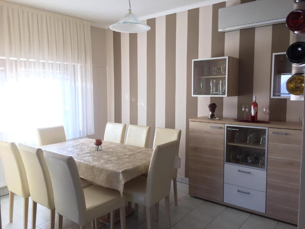 una sala da pranzo con tavolo e sedie e una cucina di Vass Bor Vendégház a Kiskőrös