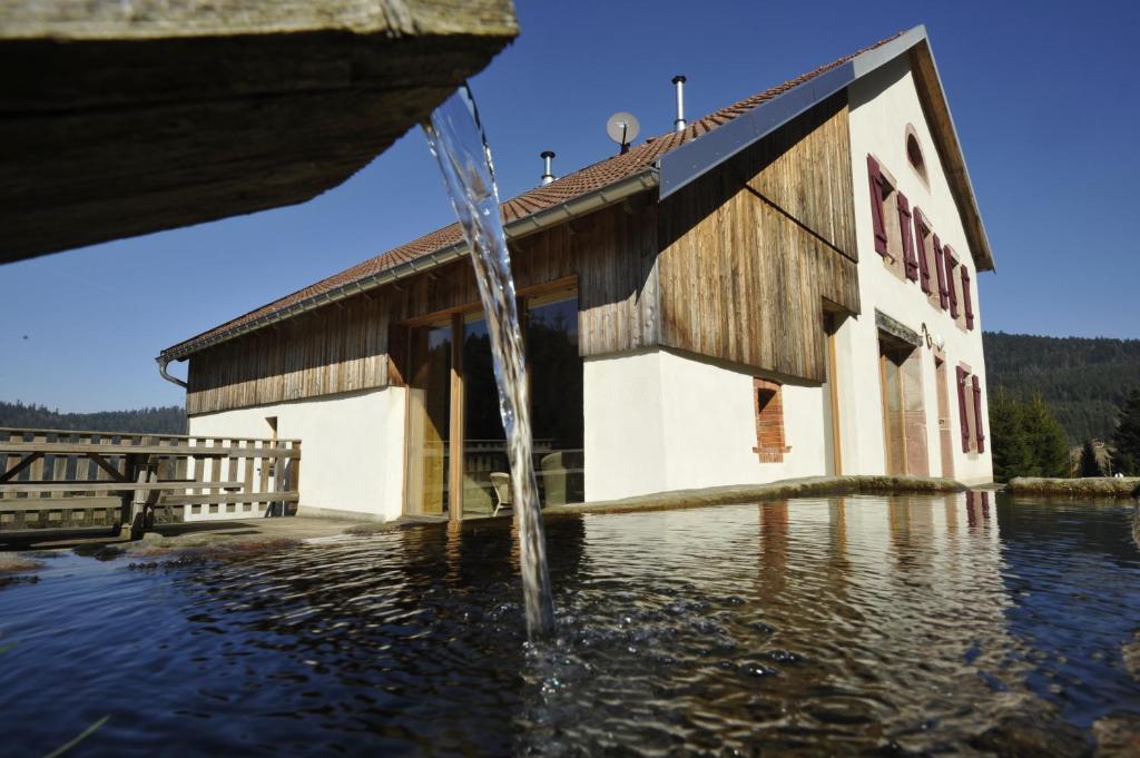 una fuente de agua frente a un edificio en Maison forestière de SCHMALICK, en Ban-sur-Meurthe-Clefcy