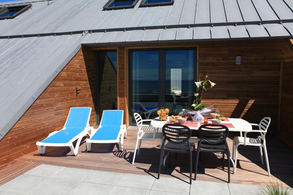 a patio with a table and chairs on a deck at Les Terrasses de l'Océan in Saint-Hilaire-de-Riez
