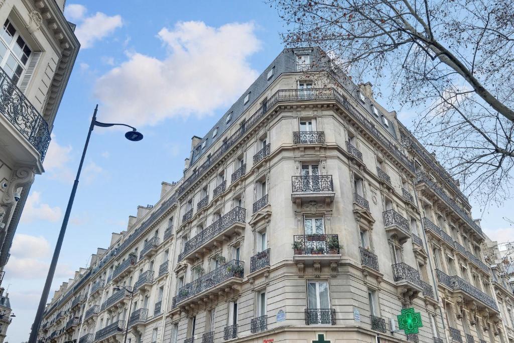 a large white building with balconies on a street at Eiffel Tower view Residence in Paris