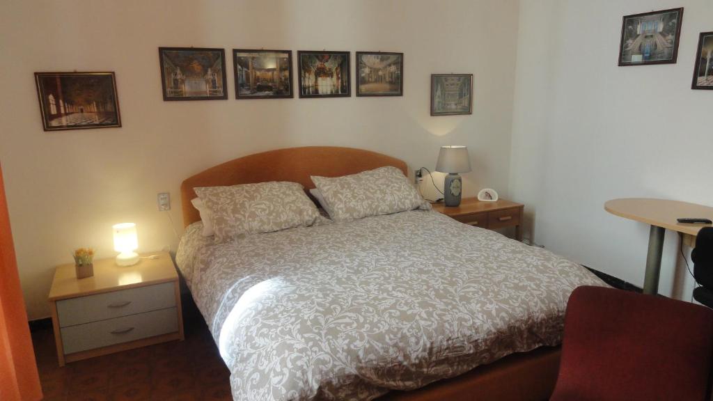 una camera da letto con un letto e due tavoli e quadri appesi al muro di PRIONE70 a La Spezia