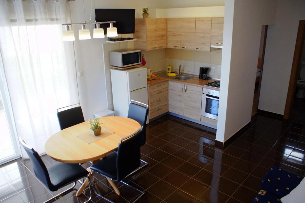 una pequeña cocina con mesa de madera y sillas en Apartments Martina, en Bibinje