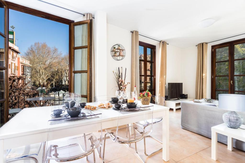 Il comprend une cuisine et un salon avec une table et des chaises. dans l'établissement Borne Suites TI by MallorcaSuites, à Palma de Majorque
