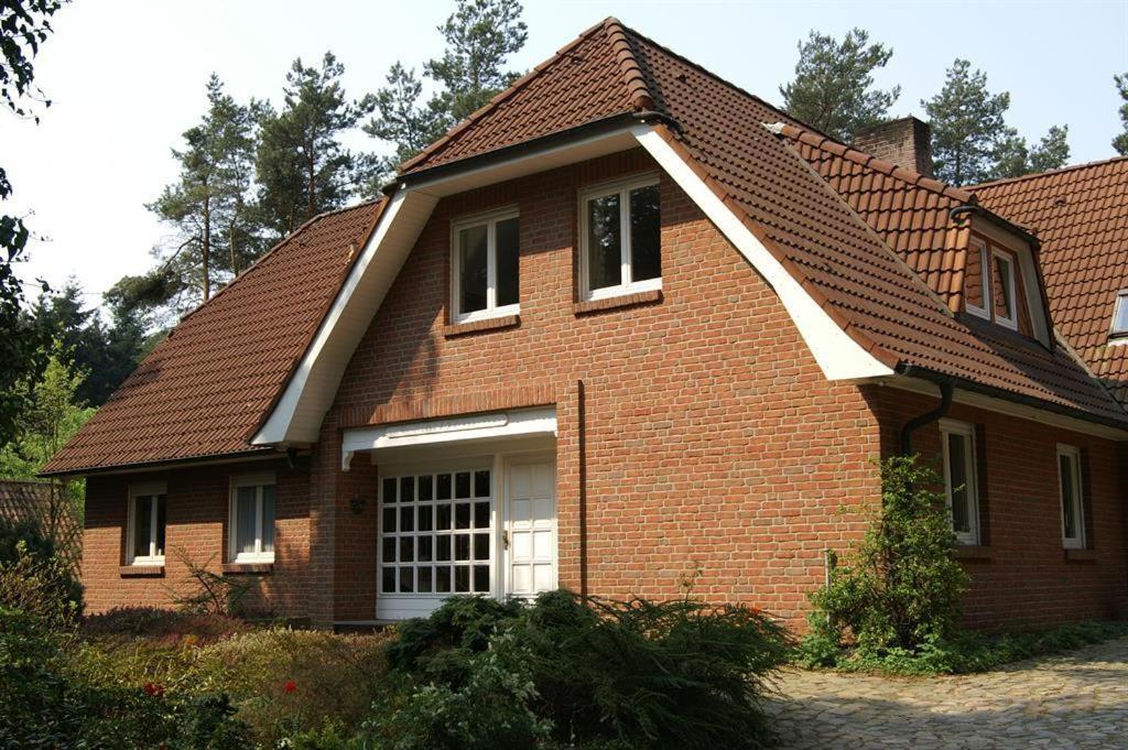 une maison en briques brunes avec un toit brun dans l'établissement Ferienwohnung Kiefernblick-Wedemann, à Bispingen