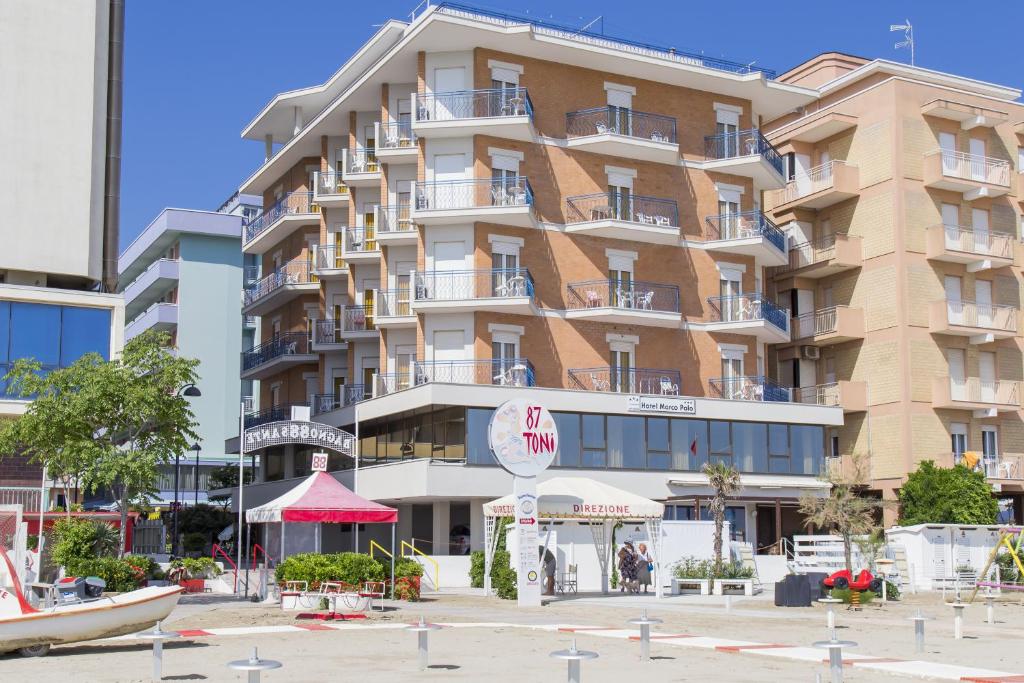 a large building with a clock in front of it at Hotel Marco Polo in Bellaria-Igea Marina