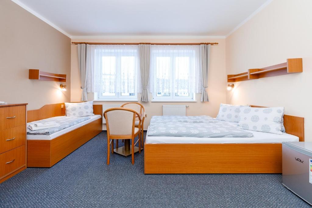 Pokój z 2 łóżkami, stołem i krzesłem w obiekcie Hotel Jitřenka w mieście Konstantinovy Lázně
