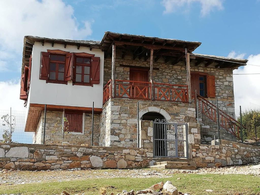 an old stone house with a balcony on top at Kastro View in Limenaria