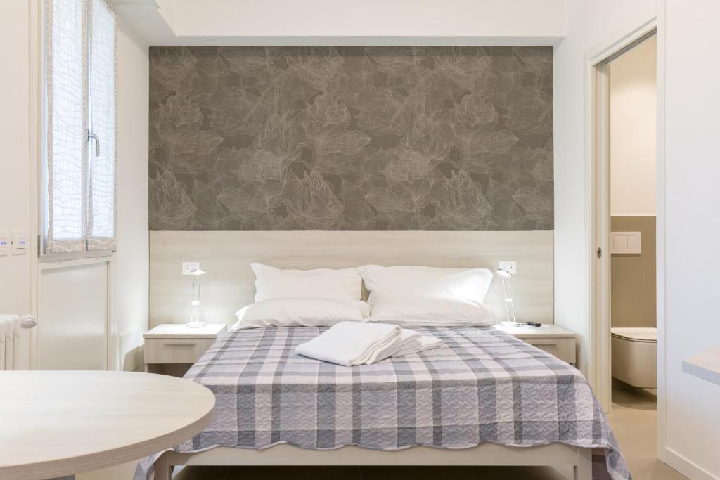 ein Schlafzimmer mit einem Bett mit einer karierten Decke in der Unterkunft B&B Open Doors Verona in Verona