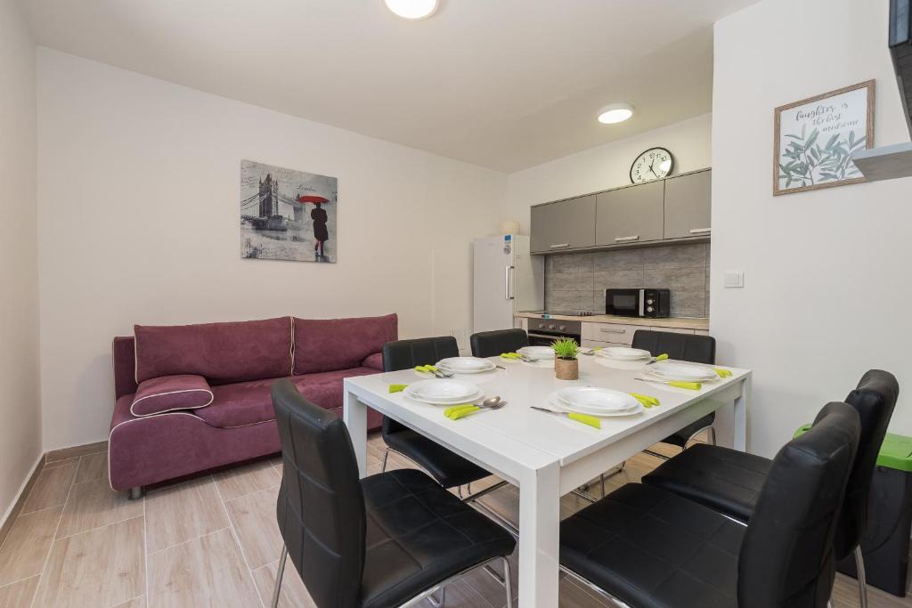 un salon avec une table, des chaises et un canapé dans l'établissement Balen city central house for 8, à Novalja