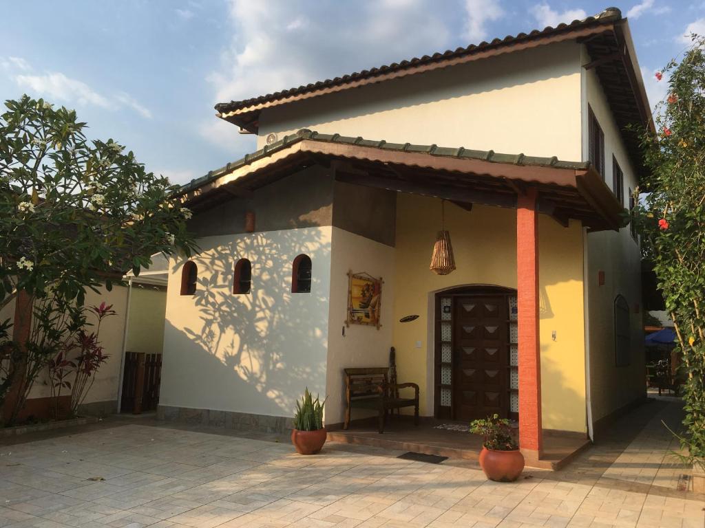 a small white house with a patio at Bertioga Beach Hostel in Bertioga