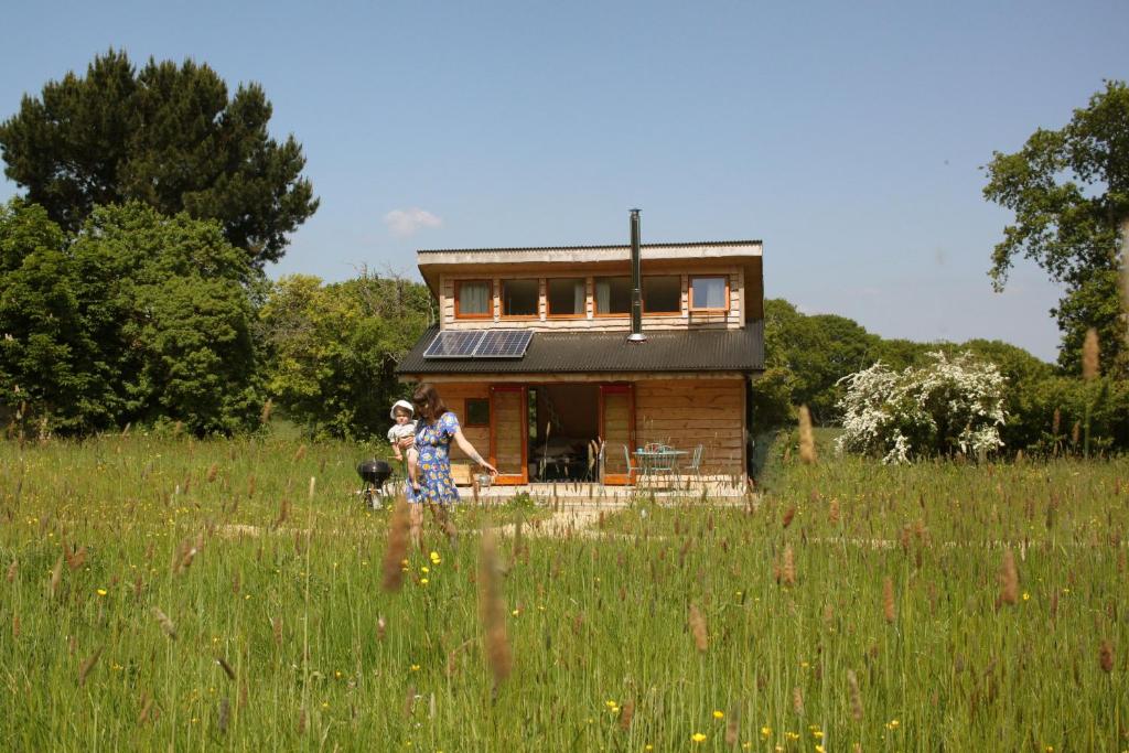 Deux personnes et un chien devant une maison dans l'établissement Tiny Home cabin Eilidh, à Cowes