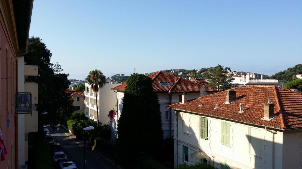 a city street with buildings and a large tree at Hotel Marcellin in Beaulieu-sur-Mer