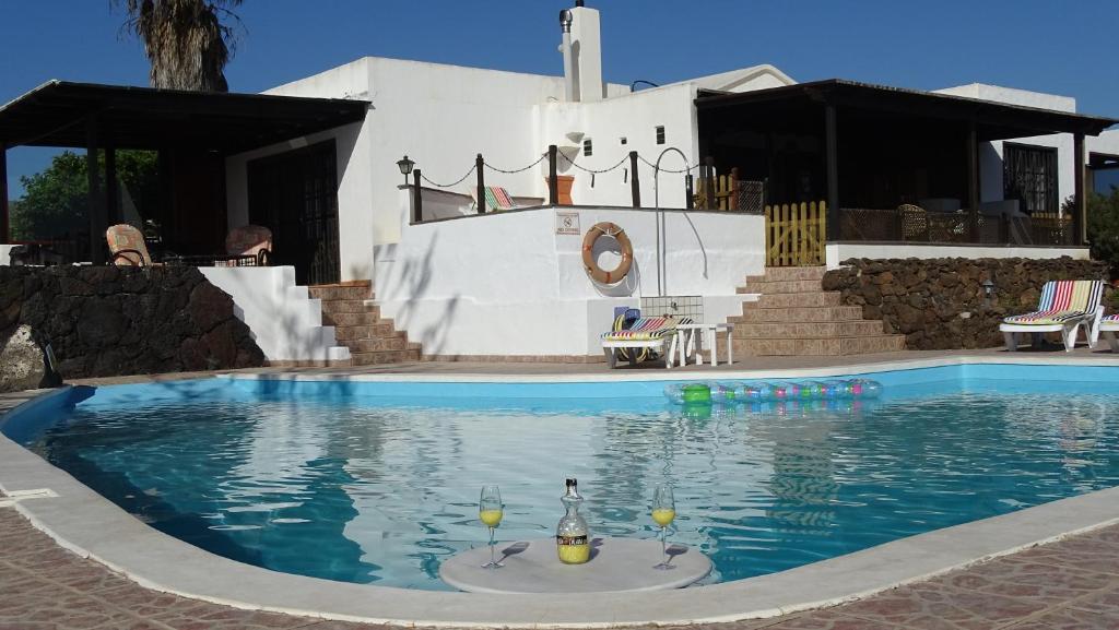 a swimming pool with two glasses of wine in it at Villa Canto in Tías