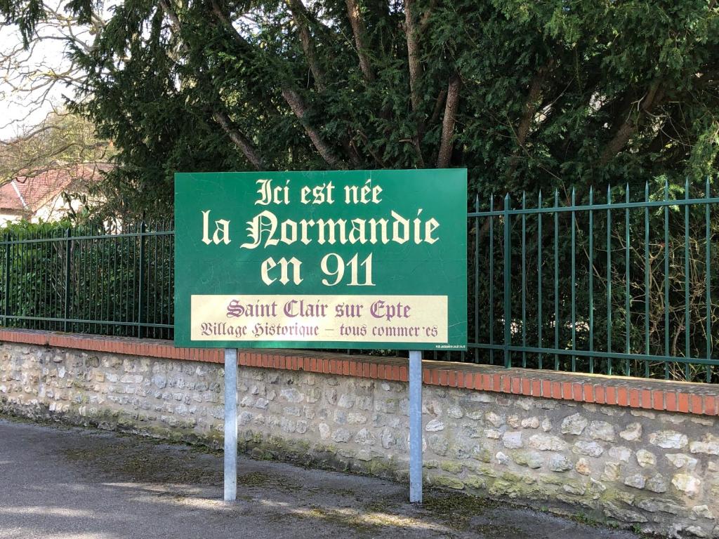 a sign is posted in front of a fence at Le logis de l'Epte in Saint-Clair-sur-Epte
