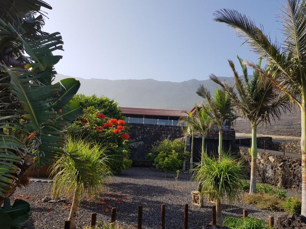a garden in front of a building with palm trees at Villa Tejeguate in Frontera