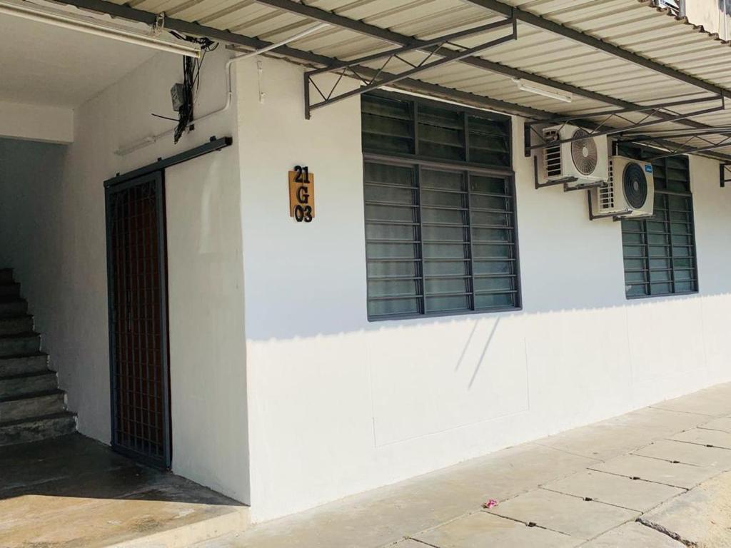 ein weißes Gebäude mit einer Tür und einigen Fenstern in der Unterkunft Abbie's Homestay Butterworth Penang in Butterworth