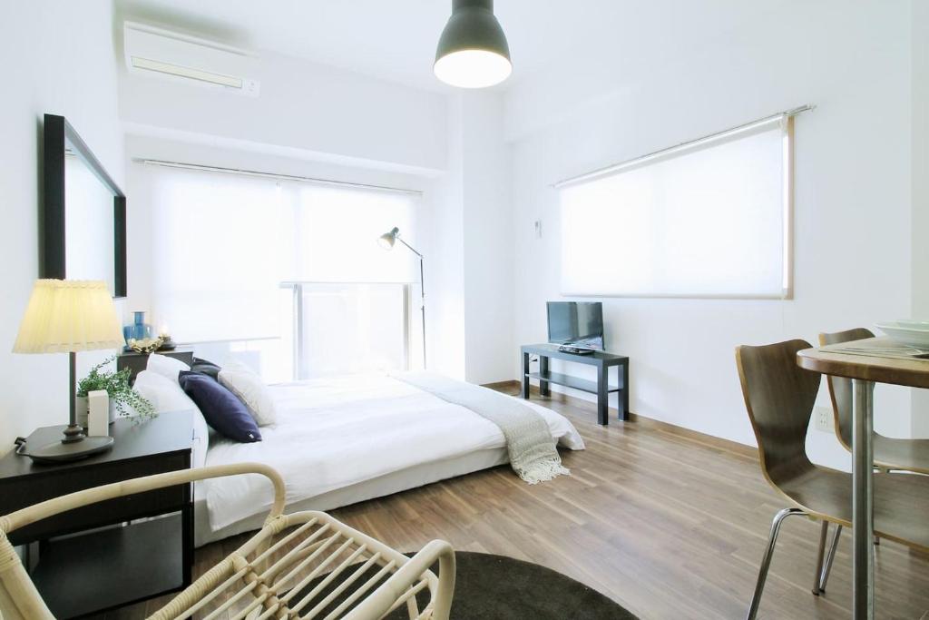 a white bedroom with a bed and a desk at Fukuromachi#702 in Hiroshima