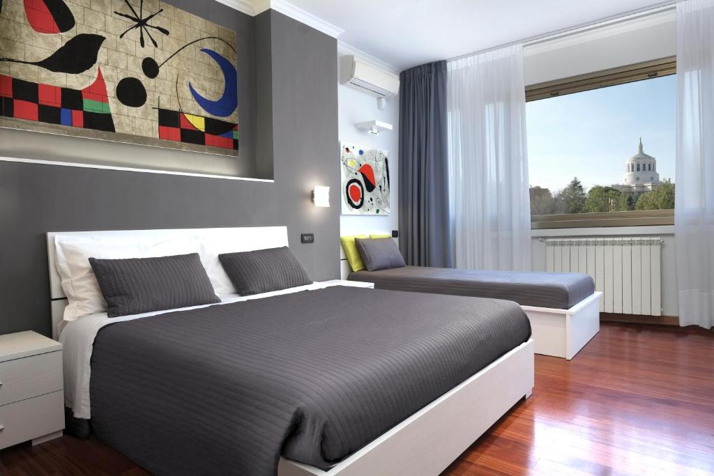 a bedroom with two beds and a large window at J24 B&B in Rome