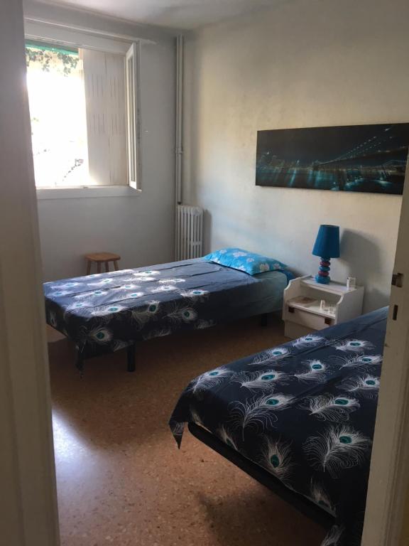 une chambre avec deux lits et une fenêtre dans l'établissement Lisa V apart, à Cannes