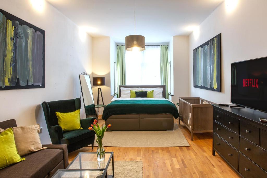 a living room with a bed and a couch at Modern family apt. with Central Square entrance in Hradec Králové