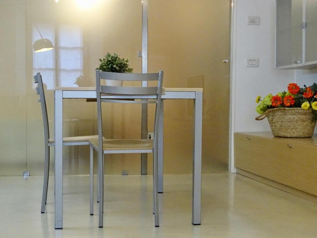 uma mesa com duas cadeiras e uma mesa com flores em Cavour 96 em Mântua