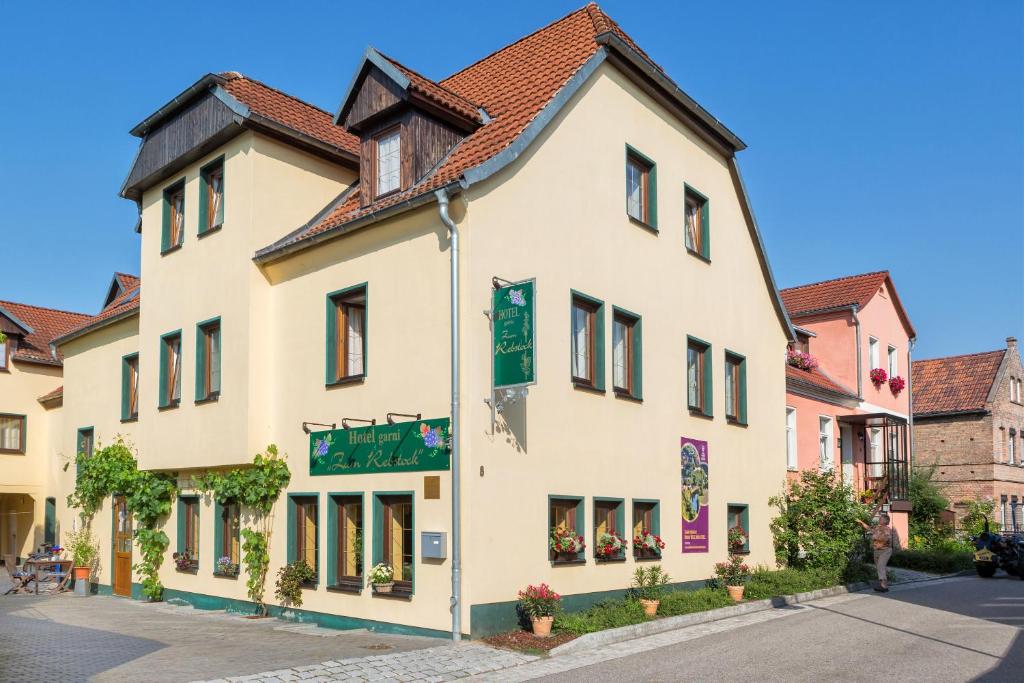 ein weißes Gebäude mit rotem Dach in der Unterkunft Hotel garni Zum Rebstock in Naumburg