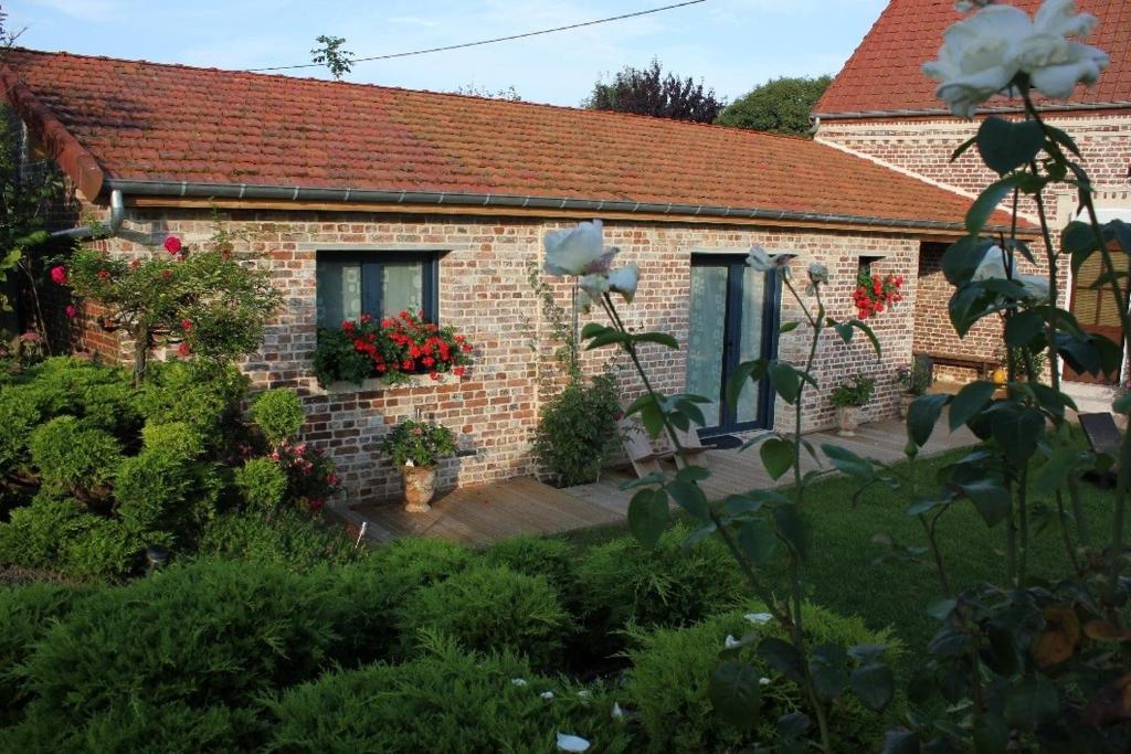 a brick house with a garden in front of it at Chambres d'hôtes La Luce in Démuin